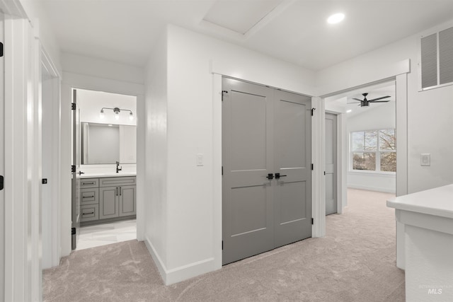 corridor with light colored carpet and sink