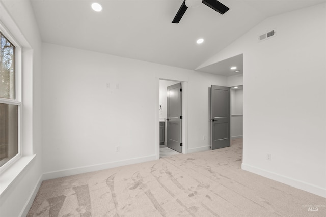 carpeted spare room with ceiling fan and vaulted ceiling