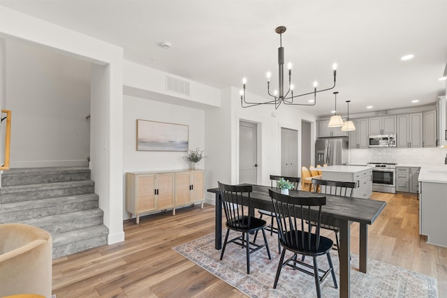 dining area featuring light hardwood / wood-style flooring and a notable chandelier