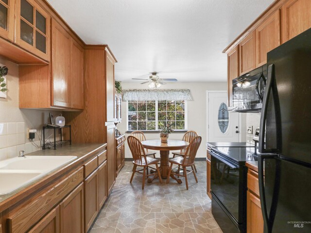 143 E Morris Ct, Kuna, ID 83634 - kitchen with black appliances, brown cabinetry, decorative backsplash, ceiling fan, and glass insert cabinets