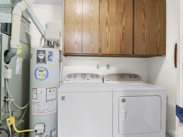 143 E Morris Ct, Kuna, ID 83634 - laundry area featuring water heater, washing machine and clothes dryer, and cabinet space