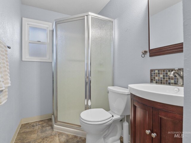 143 E Morris Ct, Kuna, ID 83634 - bathroom featuring vanity, a shower stall, stone finish flooring, and tasteful backsplash