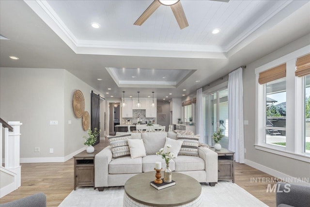 1864 N Highbury Way, Eagle, ID 83616 - living area with a tray ceiling, light wood finished floors, a ceiling fan, stairway, and crown molding