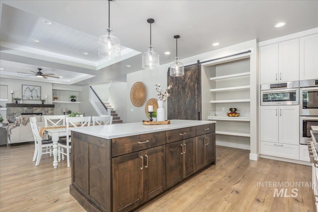 1864 N Highbury Way, Eagle, ID 83616 - kitchen with open shelves, stainless steel double oven, light wood-type flooring, dark brown cabinetry, and recessed lighting