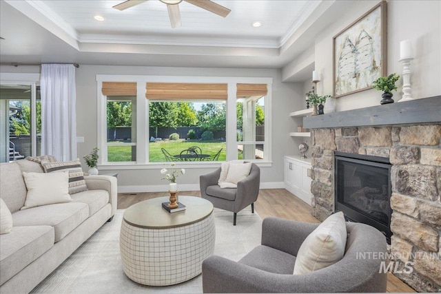 1864 N Highbury Way, Eagle, ID 83616 - living room with a tray ceiling, light wood-type flooring, ornamental molding, ceiling fan, and a fireplace