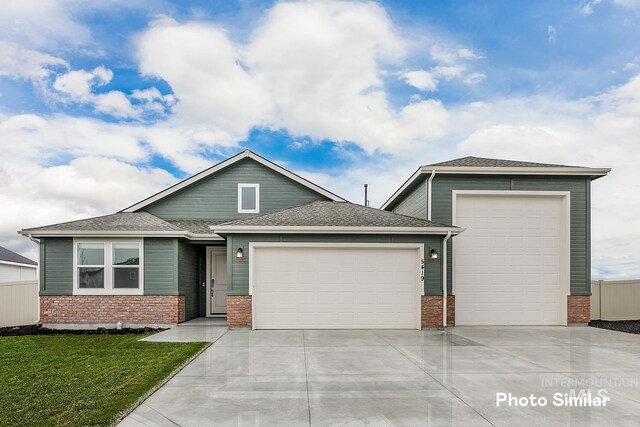 5511 E Bridal Veil Falls Dr, Nampa, ID 83686 - view of front facade with an attached garage, driveway, brick siding, a front yard, and roof with shingles