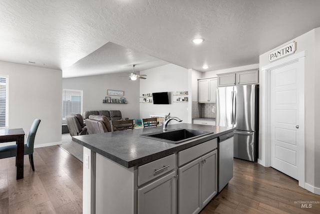 kitchen with dark countertops, appliances with stainless steel finishes, a sink, and a textured ceiling