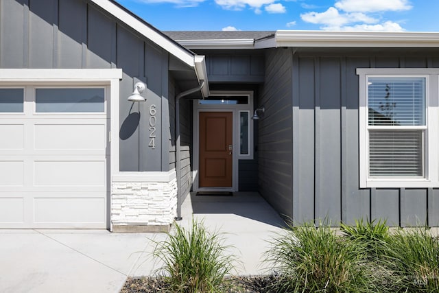 doorway to property featuring stone siding and board and batten siding