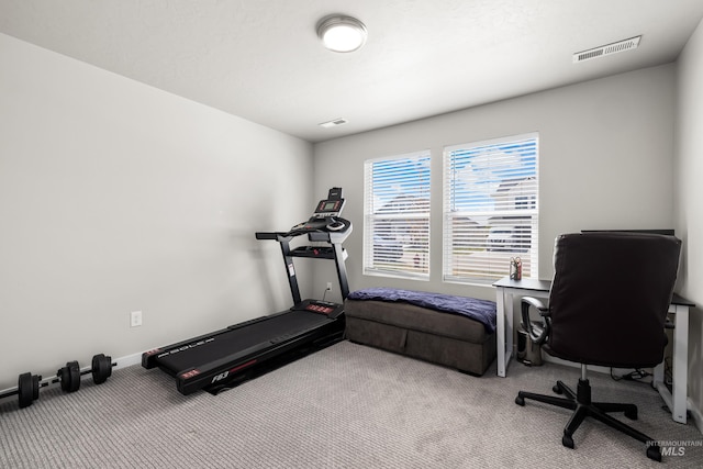 exercise room with baseboards, visible vents, and carpet floors