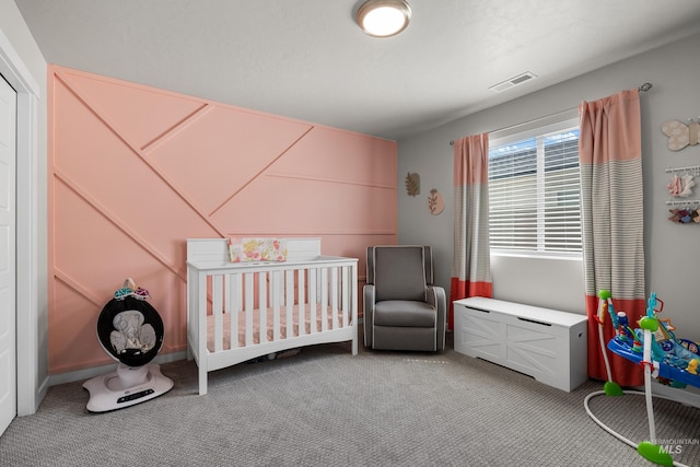 bedroom featuring light carpet, visible vents, and a nursery area