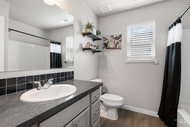bathroom featuring toilet, vanity, wood finished floors, and visible vents