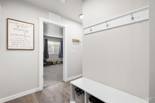 mudroom with hardwood / wood-style floors, baseboards, and visible vents
