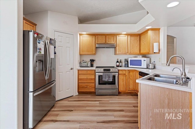 kitchen featuring a sink, light countertops, under cabinet range hood, light wood-style floors, and stainless steel appliances