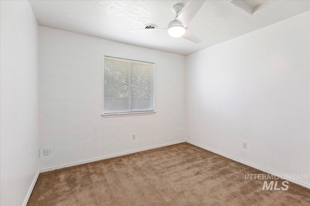empty room with baseboards, a ceiling fan, and carpet