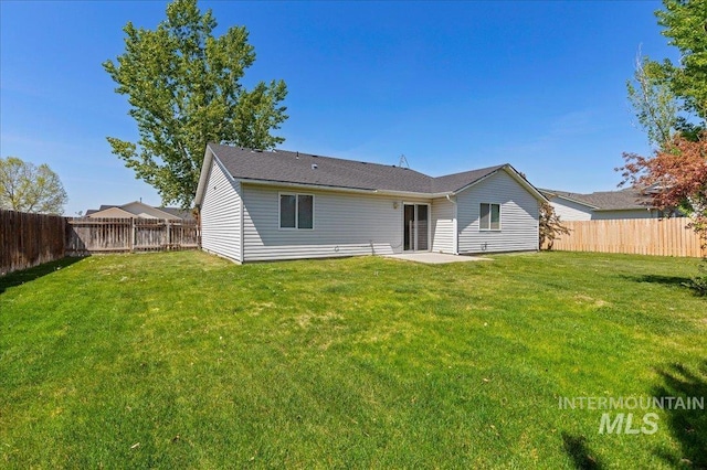 back of house with a lawn, a fenced backyard, and a patio