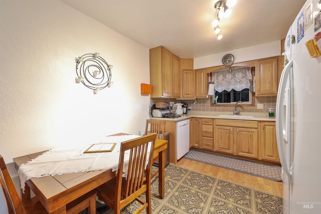 kitchen with white appliances, sink, light wood-type flooring, and decorative backsplash