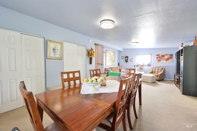 carpeted dining space with a textured ceiling