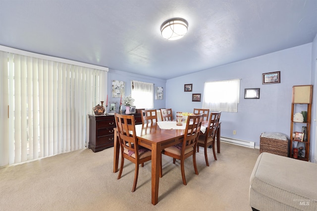 carpeted dining space featuring lofted ceiling and a baseboard radiator