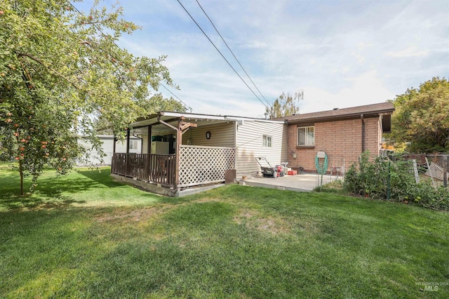 rear view of property with a patio, a lawn, and a deck