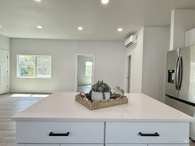 304 N C St, Grangeville, ID 83530 - kitchen featuring stainless steel refrigerator with ice dispenser, a wall unit AC, light wood-style floors, recessed lighting, and a kitchen island