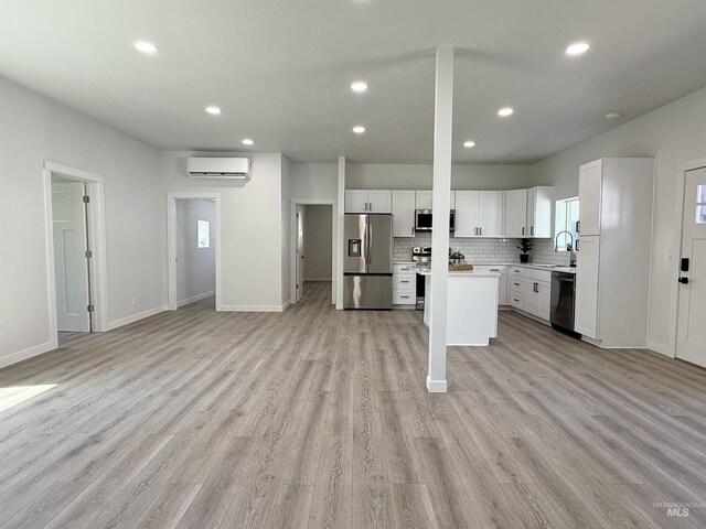 304 N C St, Grangeville, ID 83530 - kitchen featuring appliances with stainless steel finishes, a wall mounted AC, open floor plan, light countertops, and recessed lighting