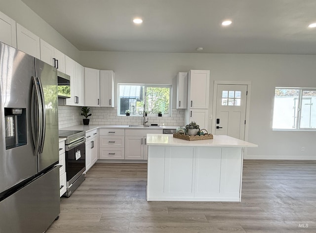 304 N C St, Grangeville, ID 83530 - kitchen with appliances with stainless steel finishes, a sink, backsplash, white cabinets, and recessed lighting
