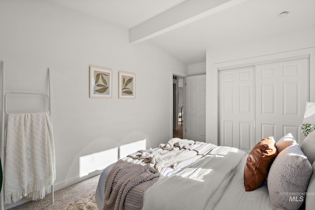 carpeted bedroom with vaulted ceiling with beams and a closet