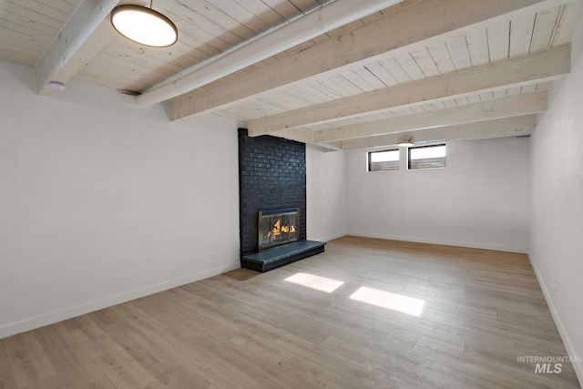 basement with wood ceiling, a brick fireplace, and light hardwood / wood-style flooring