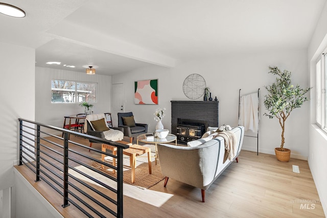 living room with beam ceiling and light wood-type flooring