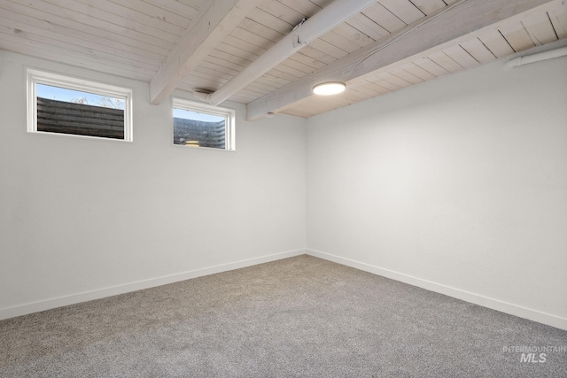 empty room featuring beamed ceiling, carpet floors, and wooden ceiling