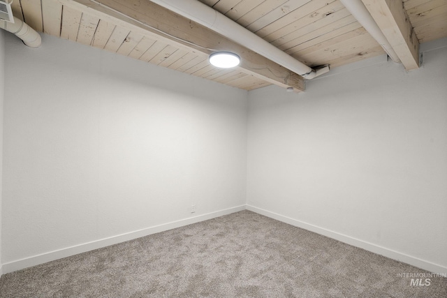 spare room featuring carpet flooring, wooden ceiling, and beam ceiling