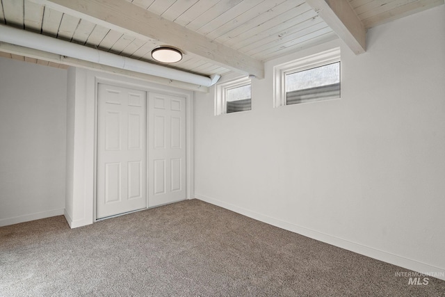 unfurnished bedroom featuring wood ceiling, a closet, carpet flooring, and beam ceiling