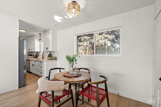 dining area with sink and light hardwood / wood-style flooring