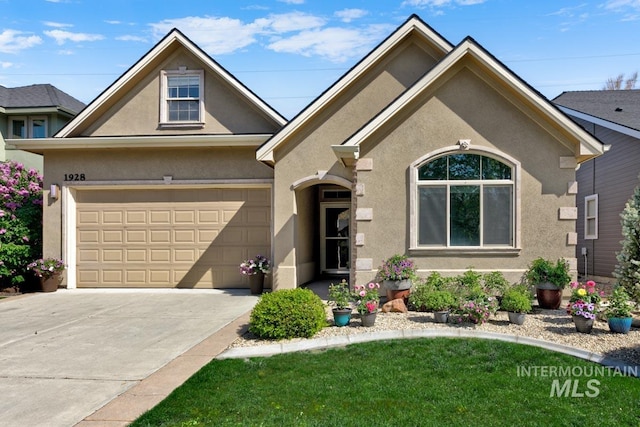 1928 E Mountain Man Dr, Meridian, ID 83646 - view of front of property with concrete driveway, a garage, a front lawn, and stucco siding