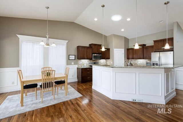 1928 E Mountain Man Dr, Meridian, ID 83646 - kitchen with appliances with stainless steel finishes, a wainscoted wall, dark wood finished floors, and dark brown cabinets