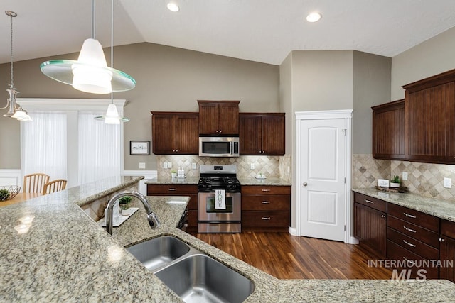 1928 E Mountain Man Dr, Meridian, ID 83646 - kitchen featuring hanging light fixtures, tasteful backsplash, a sink, stainless steel appliances, and dark wood-type flooring