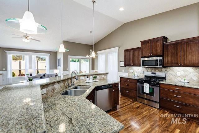 1928 E Mountain Man Dr, Meridian, ID 83646 - kitchen featuring a sink, stainless steel appliances, decorative backsplash, lofted ceiling, and dark wood-type flooring
