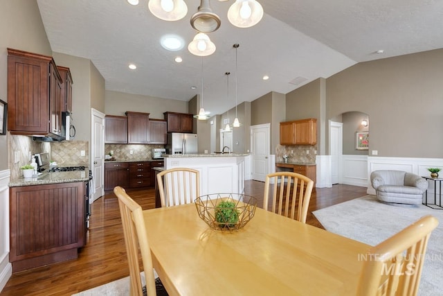 1928 E Mountain Man Dr, Meridian, ID 83646 - dining room featuring arched walkways, visible vents, wood finished floors, and lofted ceiling