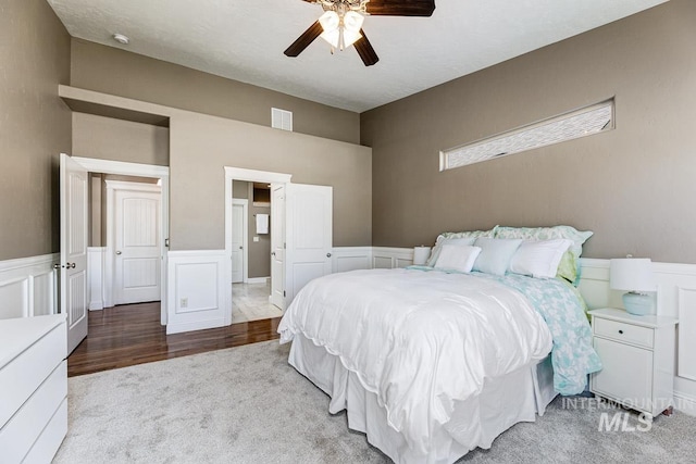 1928 E Mountain Man Dr, Meridian, ID 83646 - carpeted bedroom with a wainscoted wall, ceiling fan, a decorative wall, and visible vents