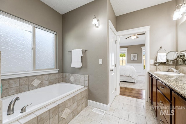 1928 E Mountain Man Dr, Meridian, ID 83646 - ensuite bathroom with tile patterned flooring, vanity, ensuite bathroom, a bath, and a ceiling fan