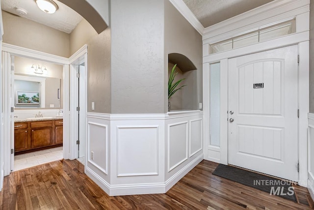 1928 E Mountain Man Dr, Meridian, ID 83646 - foyer entrance with dark wood-style flooring, arched walkways, crown molding, and a decorative wall