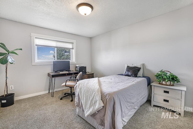 carpeted bedroom with a textured ceiling and baseboards