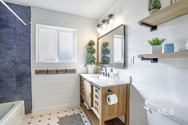 bathroom with tile patterned floors, wooden walls, shower / washtub combination, and vanity