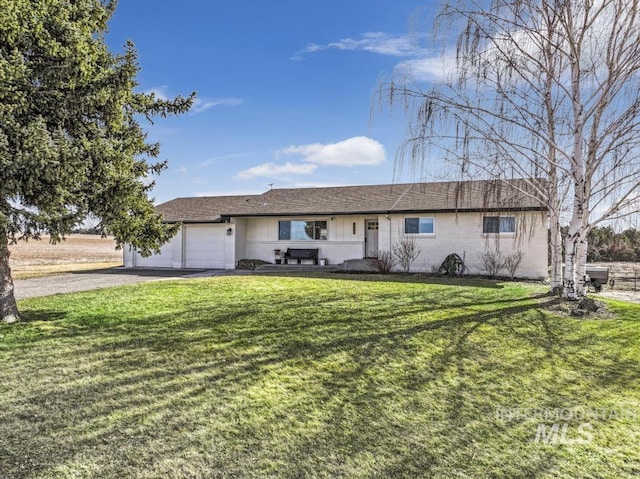 ranch-style home with aphalt driveway, brick siding, a garage, and a front lawn