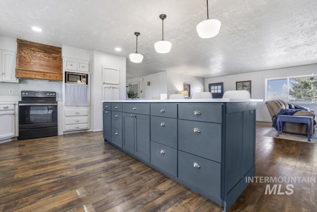 kitchen with stainless steel microwave, black range with electric stovetop, open floor plan, white cabinets, and dark wood-style flooring