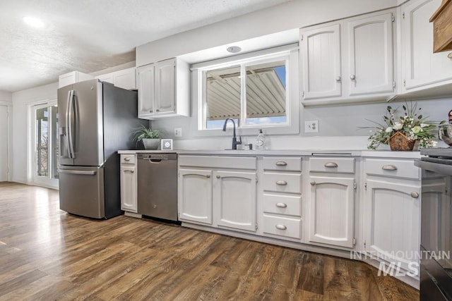 kitchen with a sink, plenty of natural light, dark wood-style flooring, and stainless steel appliances