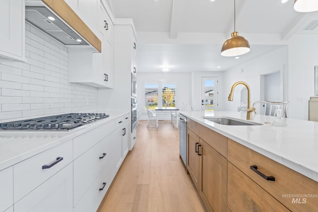 8456 W Meltwater Ln, Eagle, ID 83616 - kitchen with a sink, wall chimney range hood, appliances with stainless steel finishes, light wood-style floors, and backsplash
