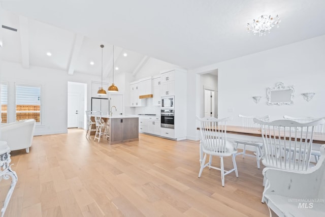 8456 W Meltwater Ln, Eagle, ID 83616 - dining room with light wood finished floors, beam ceiling, recessed lighting, baseboards, and high vaulted ceiling