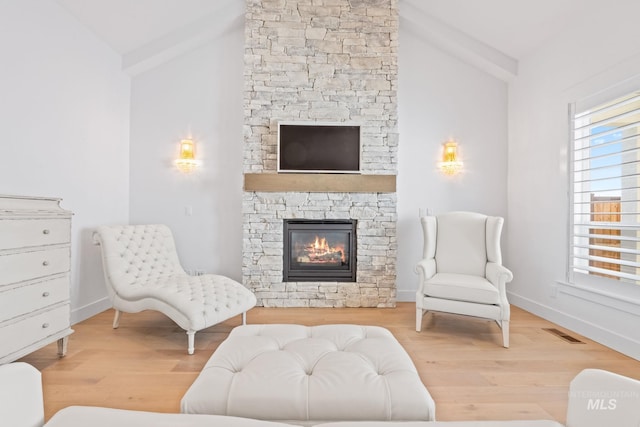 8456 W Meltwater Ln, Eagle, ID 83616 - living area featuring lofted ceiling, a fireplace, wood finished floors, and baseboards