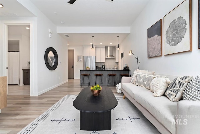 living room with baseboards, recessed lighting, light wood-style flooring, and visible vents